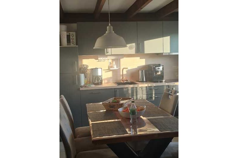 Moderne Küche mit Holzboden, stilvoller Beleuchtung und elegantem Design.