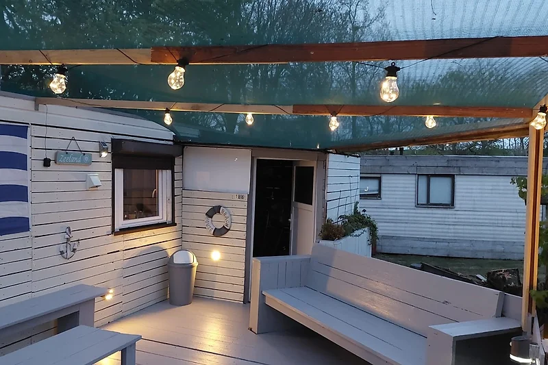 Terrasse mit Holzmöbeln und Sitzgelegenheit.