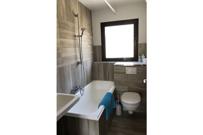 Gemütliches Badezimmer mit Holzfußboden und stilvoller Einrichtung.