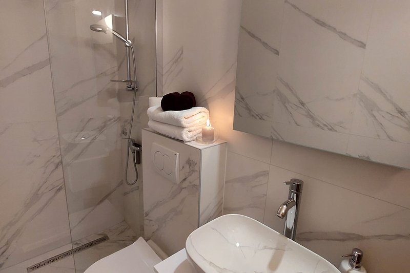 Elegantna kupaonica s bijelim umivaonikom i modernim svjetiljkama.