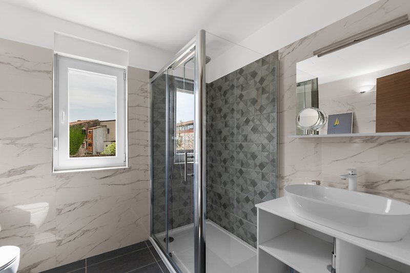 Elegantes Badezimmer mit moderner Dusche und stilvoller Einrichtung.