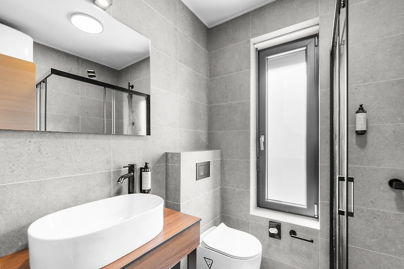 Elegantes Badezimmer mit schwarzen Armaturen und Spiegel.