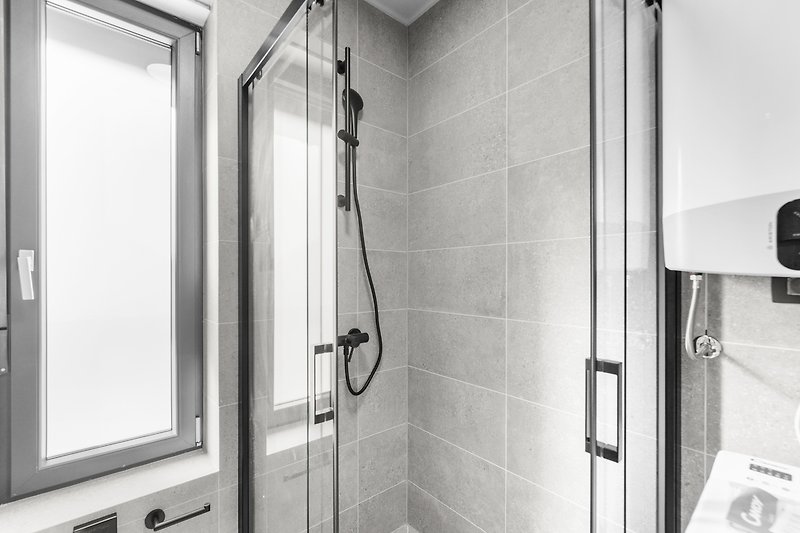 Schwarze Dusche mit Glaswand und Aluminiumgriffen.