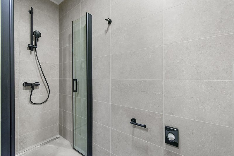 Modernes Badezimmer mit Dusche und Glaswand.