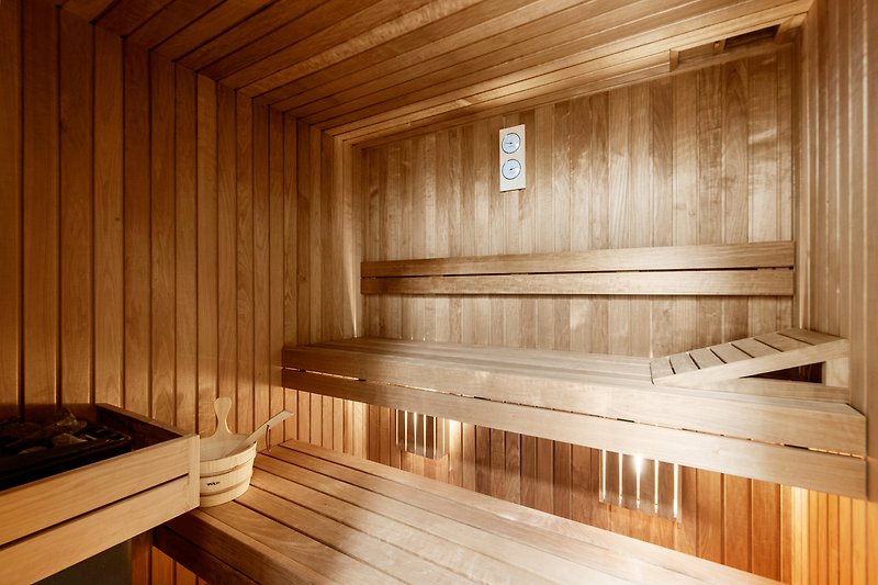 Geräumige Sauna mit Holzverkleidung und Deckenbalken.