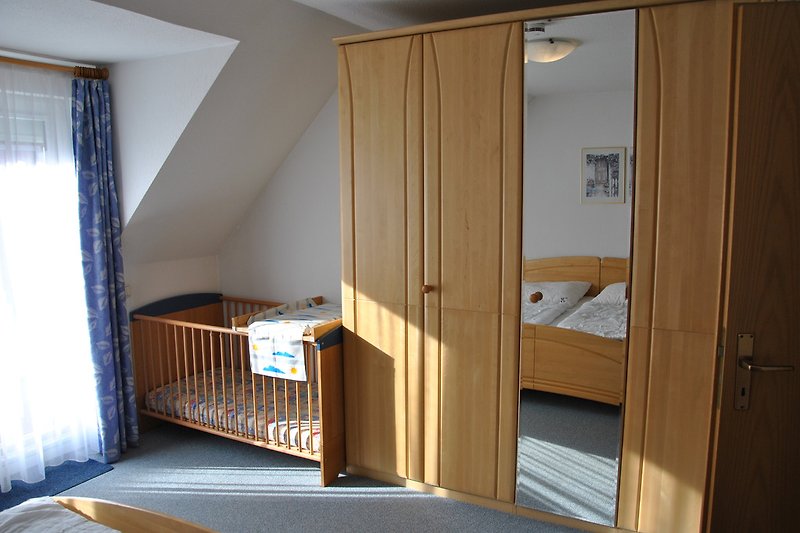 Schlafzimmer 2: Blick auf das Kinderbett vom Doppelbett aus