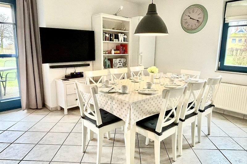 Moderne Küche mit Esstisch, Stühlen und großem SMART-TV