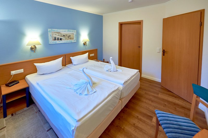 Gemütliches Schlafzimmer mit blauem Bett und Holzmöbeln.