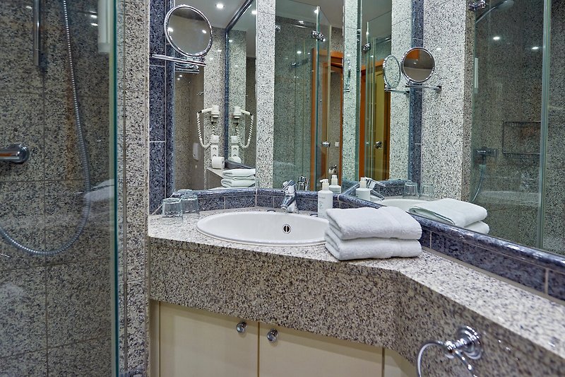 Ein stilvolles Badezimmer mit Marmorwaschbecken und Badewanne.