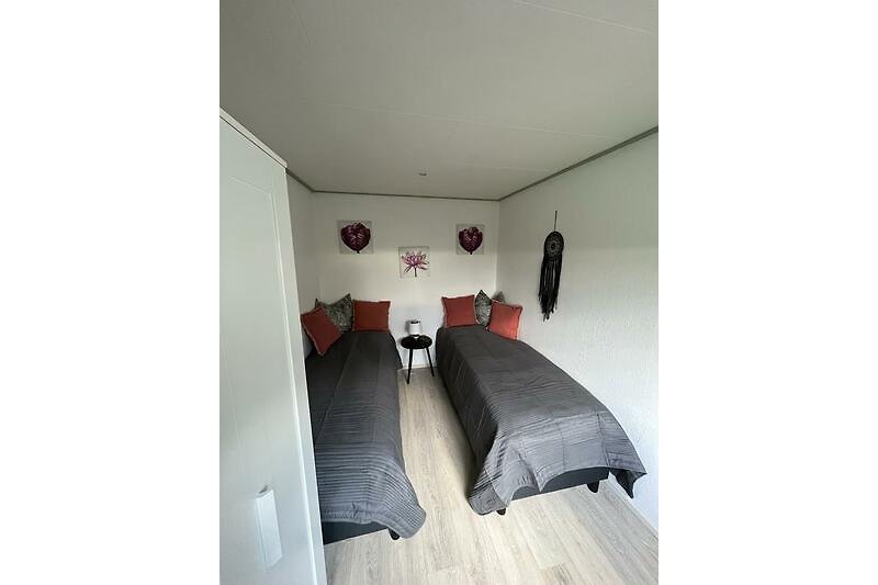 2. Gemütliches Schlafzimmer mit Laminatboden und zwei gemütlichen Betten.