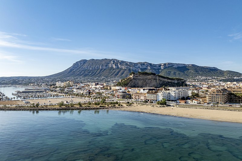 Küstenlandschaft mit Bergen, Meer und Sandstrand.