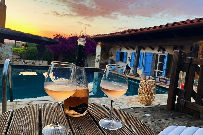 Wein am Tisch mit Meerblick und Sonnenuntergang.