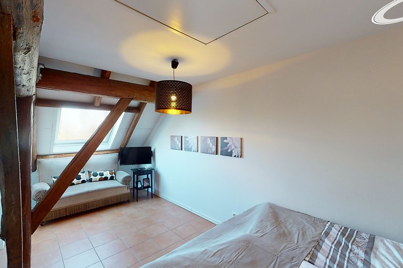 Wohnzimmer mit Holzmöbeln, stilvoller Beleuchtung & gemütlichem Bett.