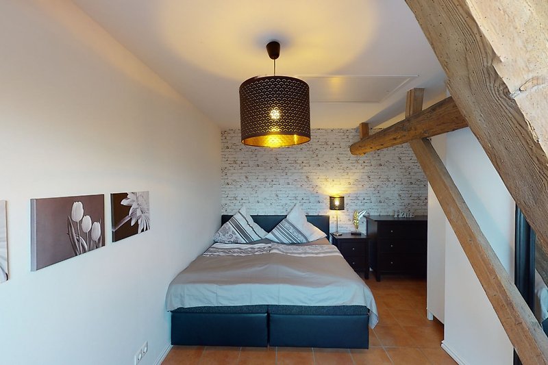 Schlafzimmer mit stilvoller Beleuchtung und Holzmöbeln.
