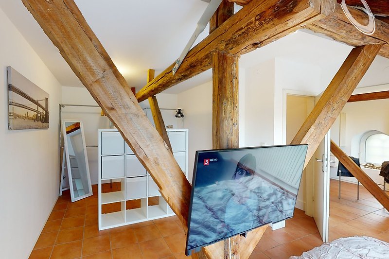 Geräumiges Wohnzimmer mit Holzbalken, Kunst und Glas.