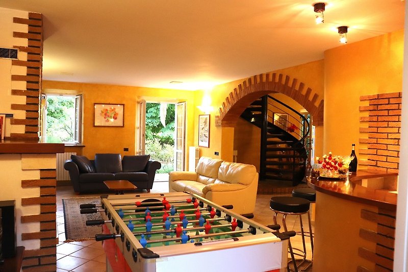 Large lounge with bar corner, table football and fireplace