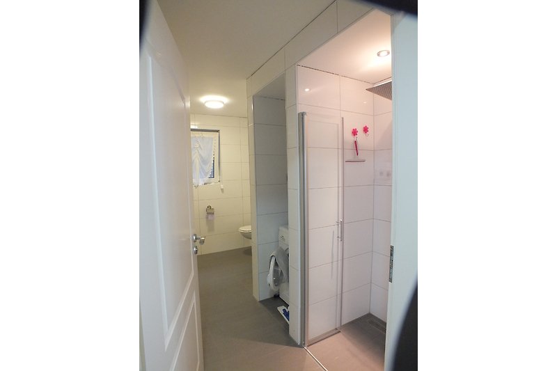 Schönes Badezimmer mit moderner Dusche, Fliesen und stilvoller Einrichtung.