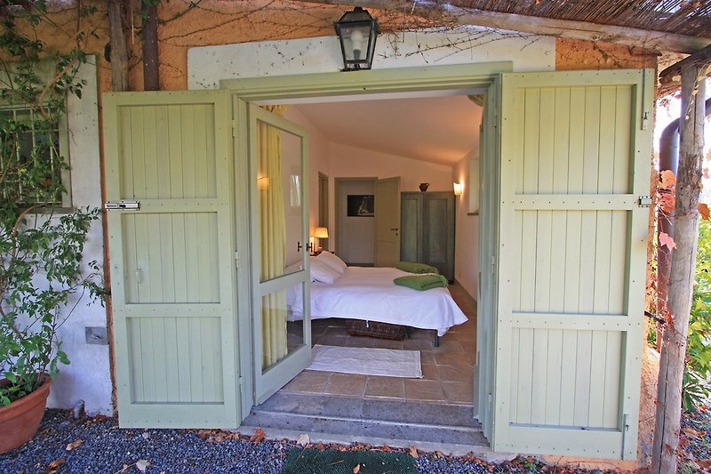 Blick von gedeckter Veranda auf Schlafzimmer