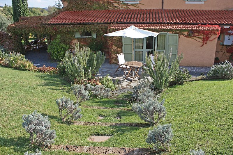 Ferienwohnung mit Sitzgruppe und Sonnenschirm