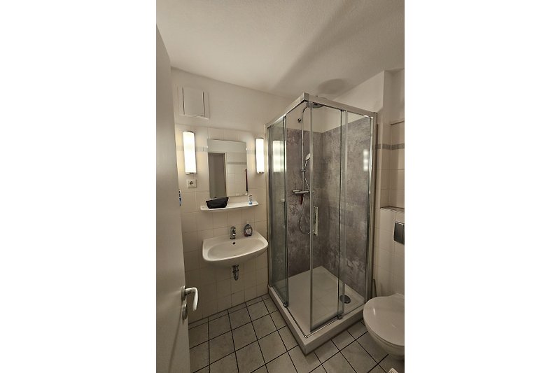 Badezimmer mit neuer moderner Duschkabine, "Regenwalddusche" und Designelementen