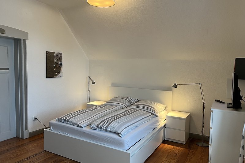 Stilvolles Schlafzimmer mit bequemem Bett und eleganter Beleuchtung.