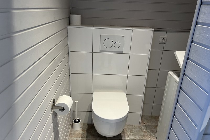 Modernes Badezimmer mit stilvoller Fliesenverkleidung und Toilette.