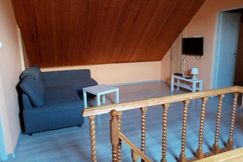 Wohnzimmer mit Holzmöbeln, gemütlicher Couch und schöner Einrichtung.