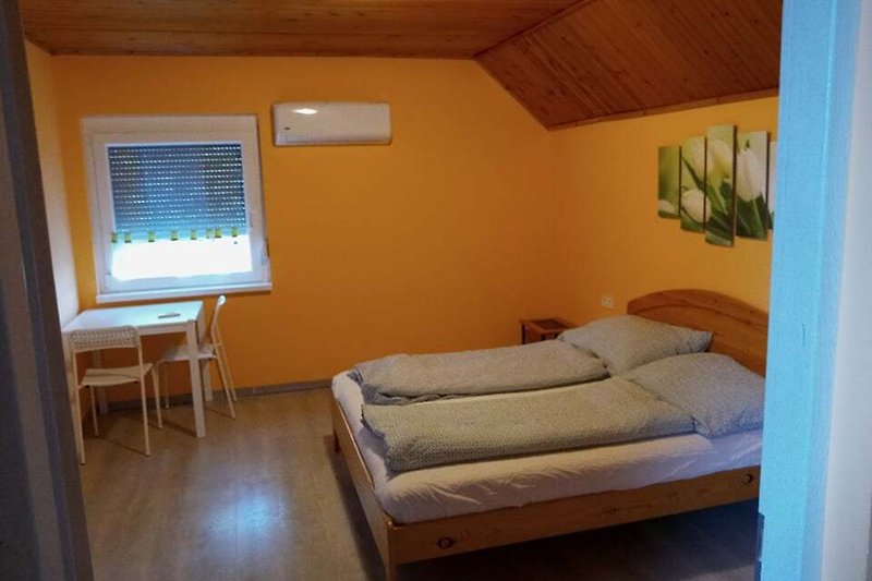 Stilvolles Zimmer mit Holzmöbeln, bequemem Bett und schöner Inneneinrichtung.