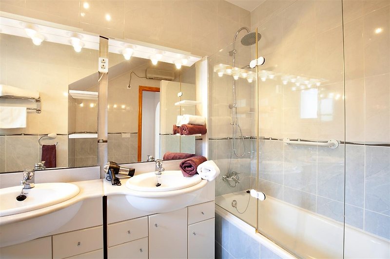Spacious bathroom with double vanity and bathtub with rain shower