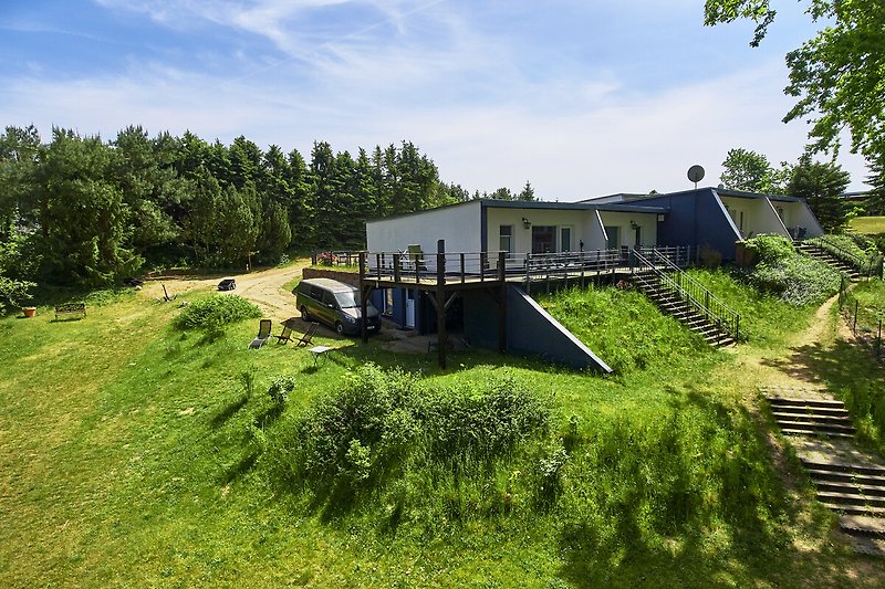 Ein idyllisches Haus mit schönem Garten und Blick auf eine grüne Landschaft.