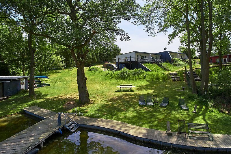 Ein Haus mit grünem Garten, Teich und idyllischer Landschaft.