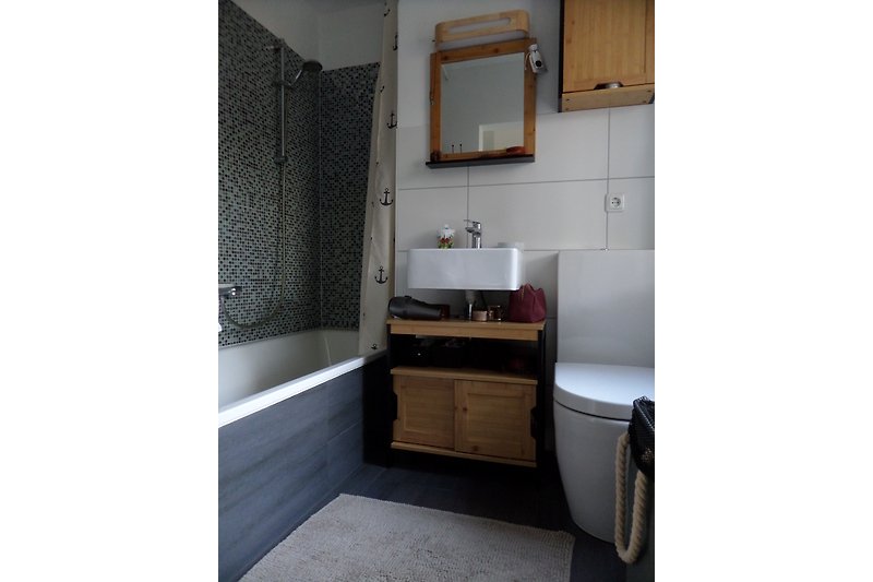 Kleines Badezimmer mit Wanne/Duschvorhang, Waschbecken und Toilette