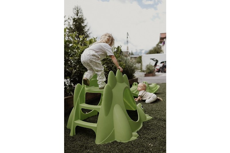 Schöner Spielplatz mit glücklichen Kindern und grüner Landschaft.