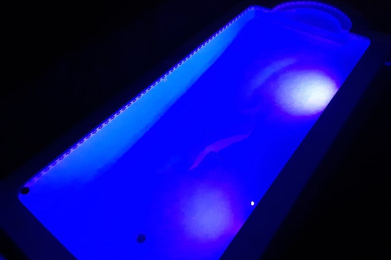 Futuristische Beleuchtungseffekte in violettem Raum. Neon-Display und Glasfasade.