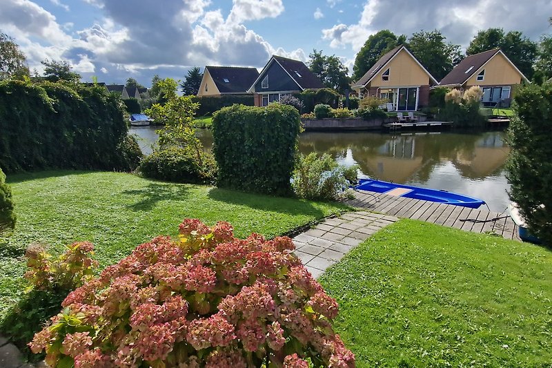 Prachtig huis met groene tuin, blauwe lucht en een prachtig uitzicht op het meer.