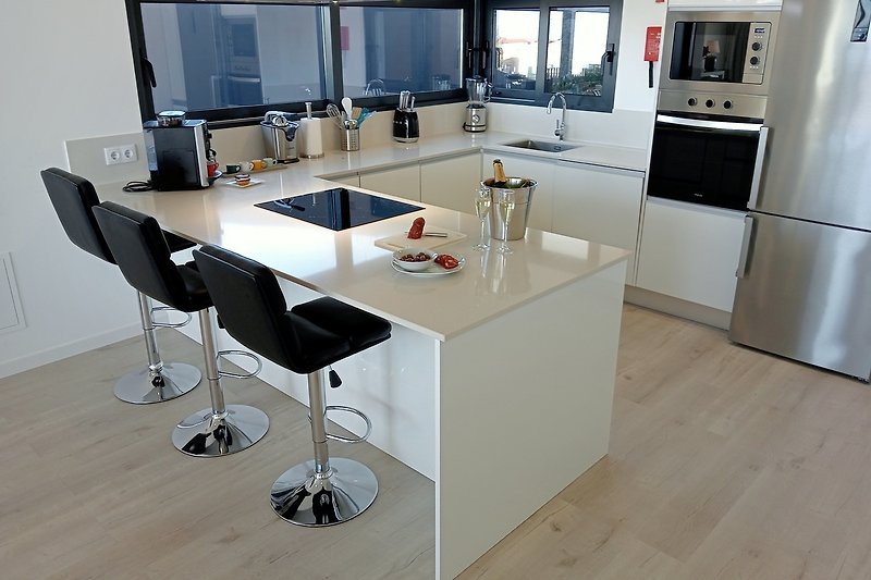 Moderne Küche mit elegantem Mobiliar und hochwertigen Geräten.