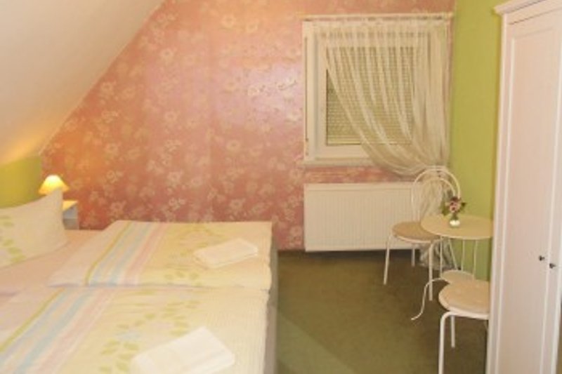 Schlafzimmer 1 mit Doppelbett, Kleiderschrank, Tisch u. Stühlen
