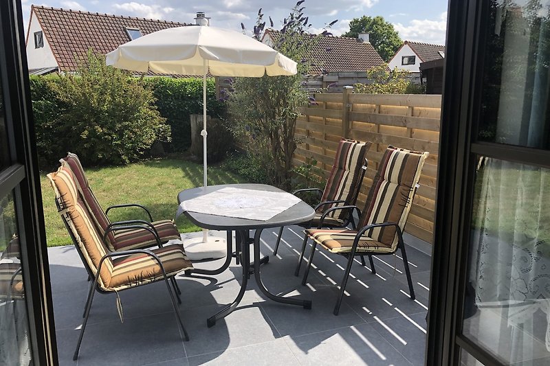 Terrasse mit Tisch, Stühle/Polster und Sonnenschirm