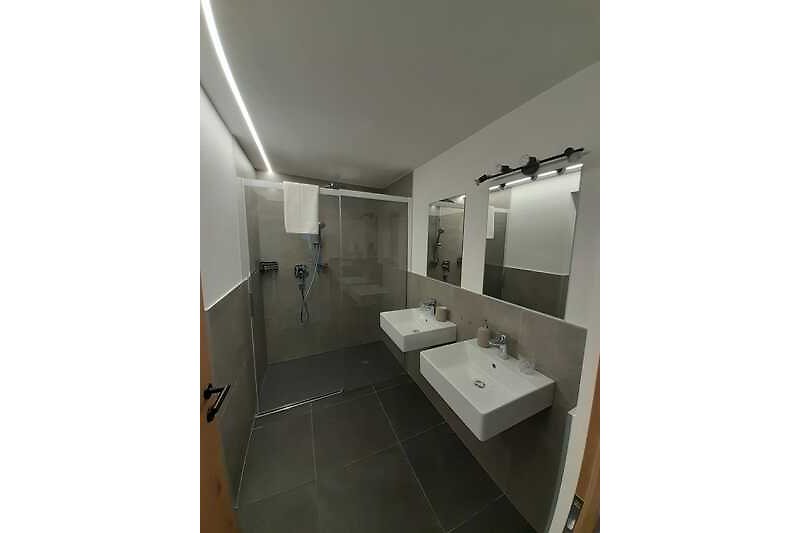 Schönes Badezimmer mit Spiegel, Waschbecken und Armatur.