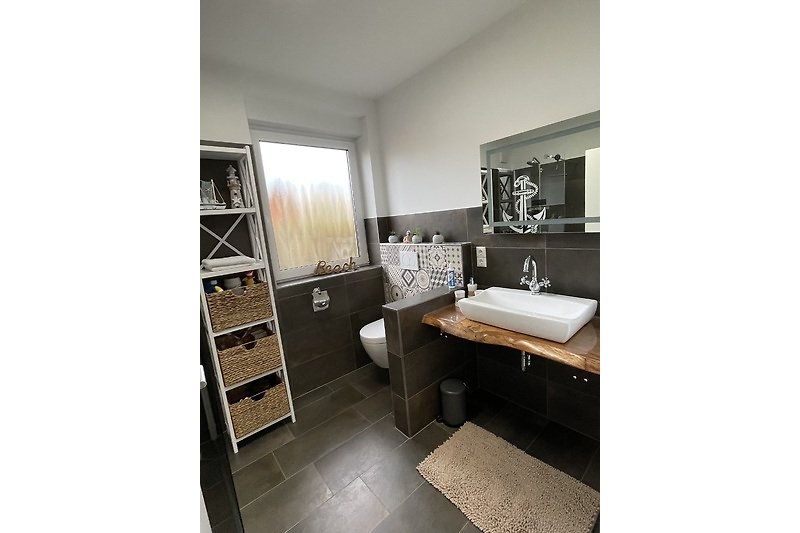 Ein stilvolles Badezimmer mit Fliesenboden und elegantem Waschbecken.