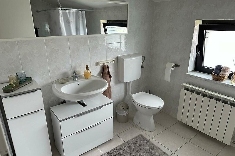 Ein stilvolles Badezimmer mit lila Akzenten und modernen Sanitäranlagen.
