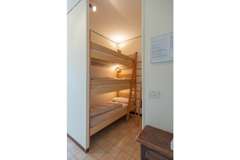 Open sleeping chamber with triple bunk bed.