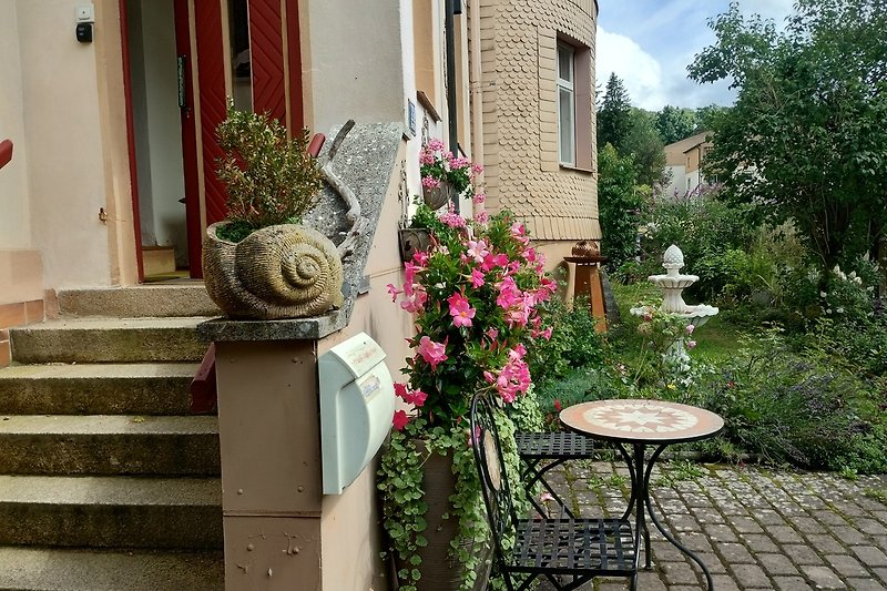 Schönes Haus mit blühenden Pflanzen und malerischer Fassade.