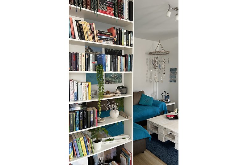 Blick in den Wohnraum mit Bücherauswahl & großer, gemütlicher Couch