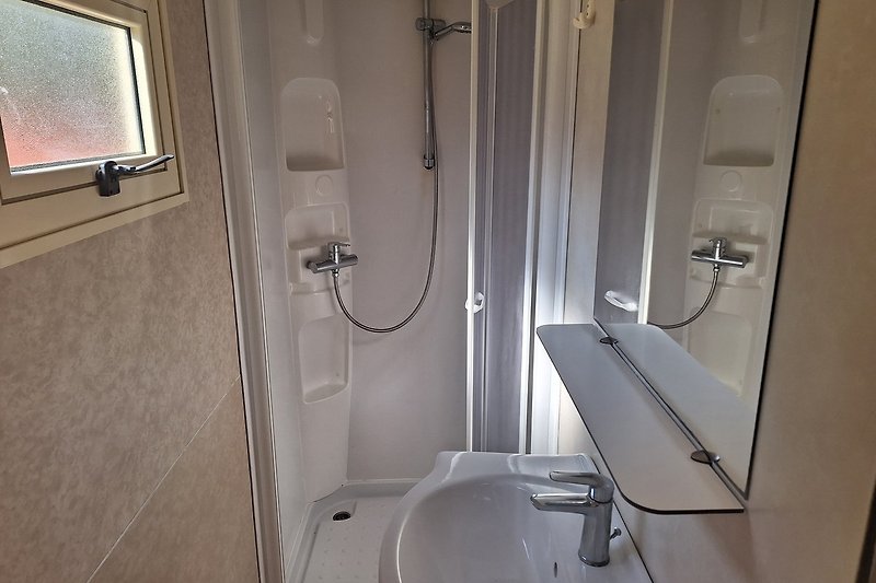 Mooie badkamer met verzorgde douche en douchewand