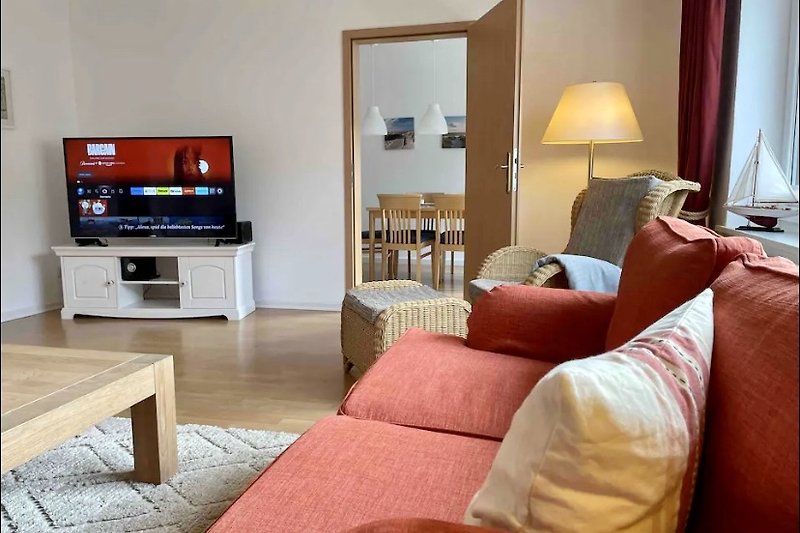 Gemütlicher Wohnbereich mit bequemer Couch und Fernseher.