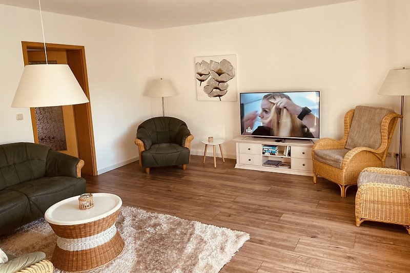 Gemütliches Wohnzimmer mit bequemer Couch und Holzmöbeln.