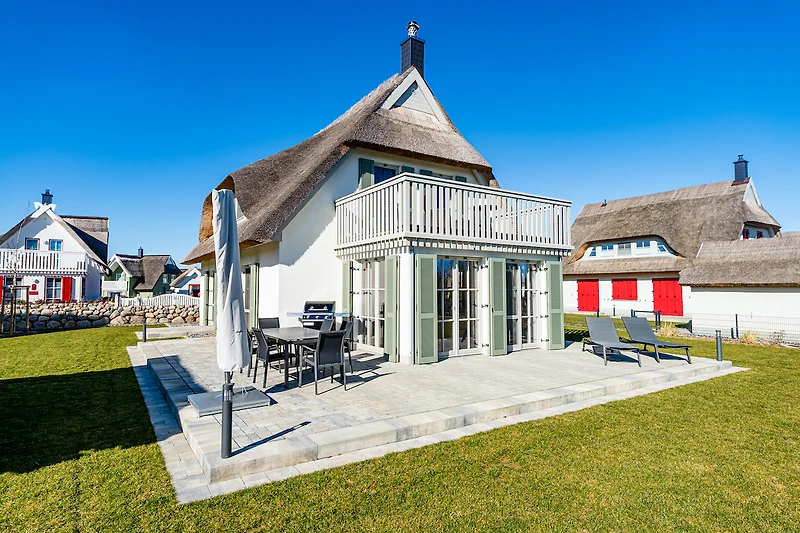 Gartenseite mit Balkon, Terrasse, Sonnenschirm und Gasgrill