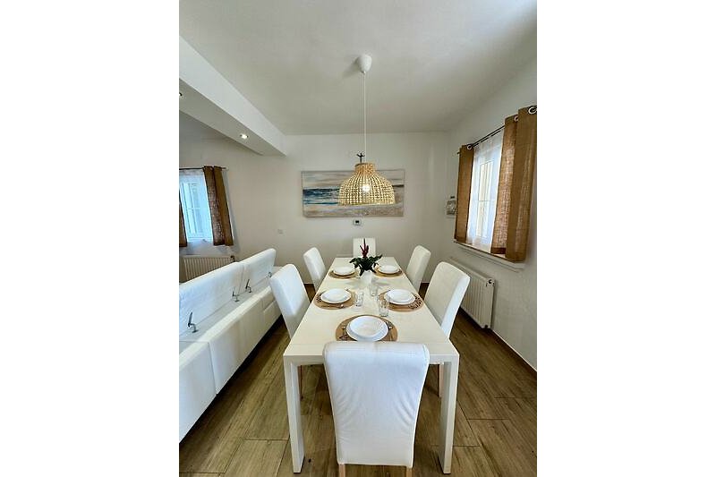 Elegante Küche mit Holztisch und Stühlen.