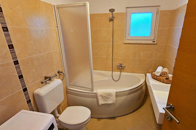 Modernes Badezimmer mit lila Dusche und Badewanne.
